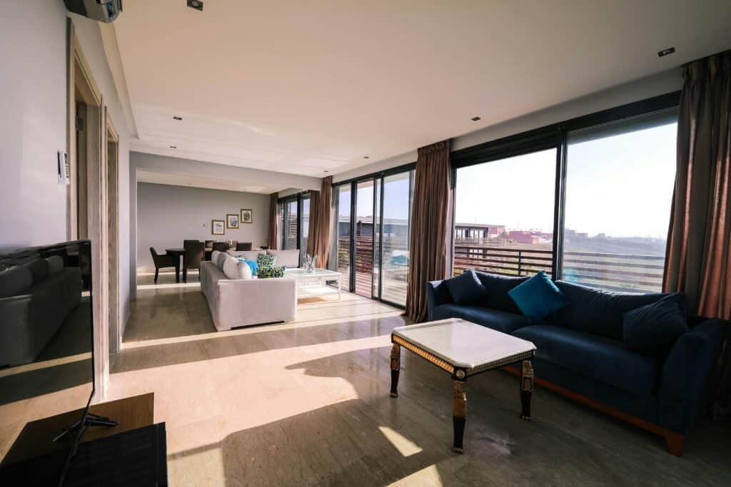 Bright and airy contemporary living room with furniture and large windows overlooking a city view. Sliding Door Repair Gallery